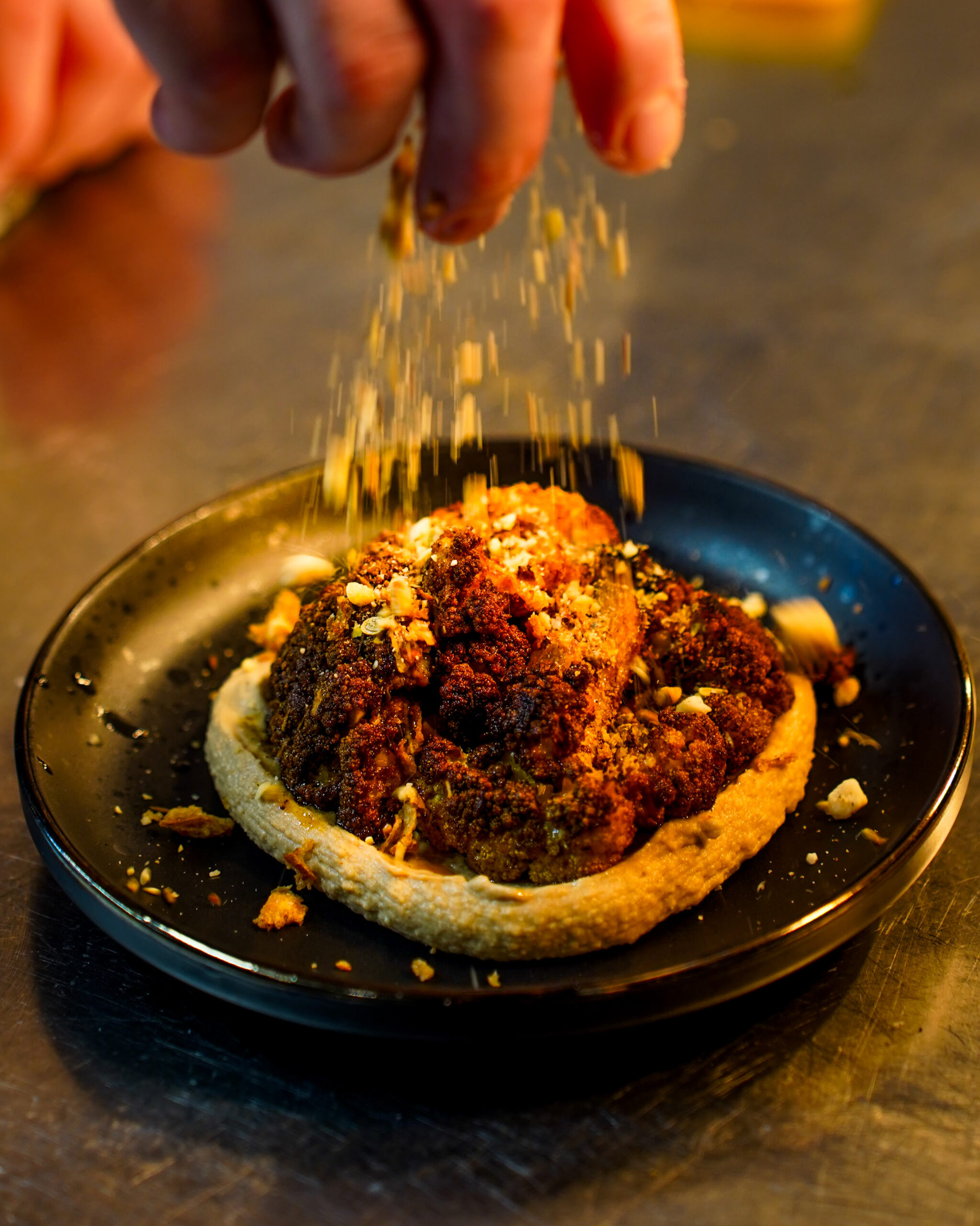 Chef sprinkling crumb onto food